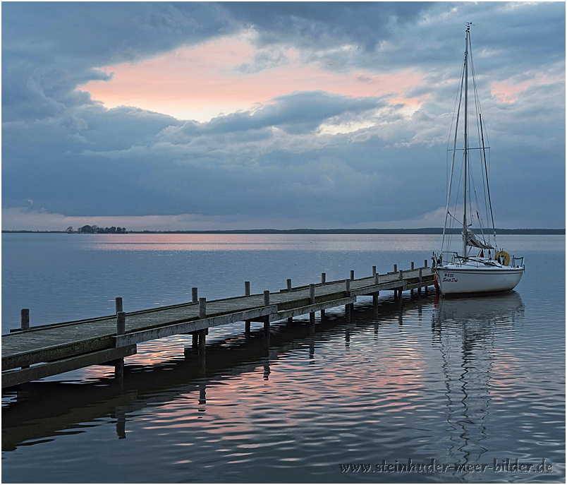 Segelboot am Steg auf dem Steinhuder Meer bei Abenddämmerung in der blauen Stunde