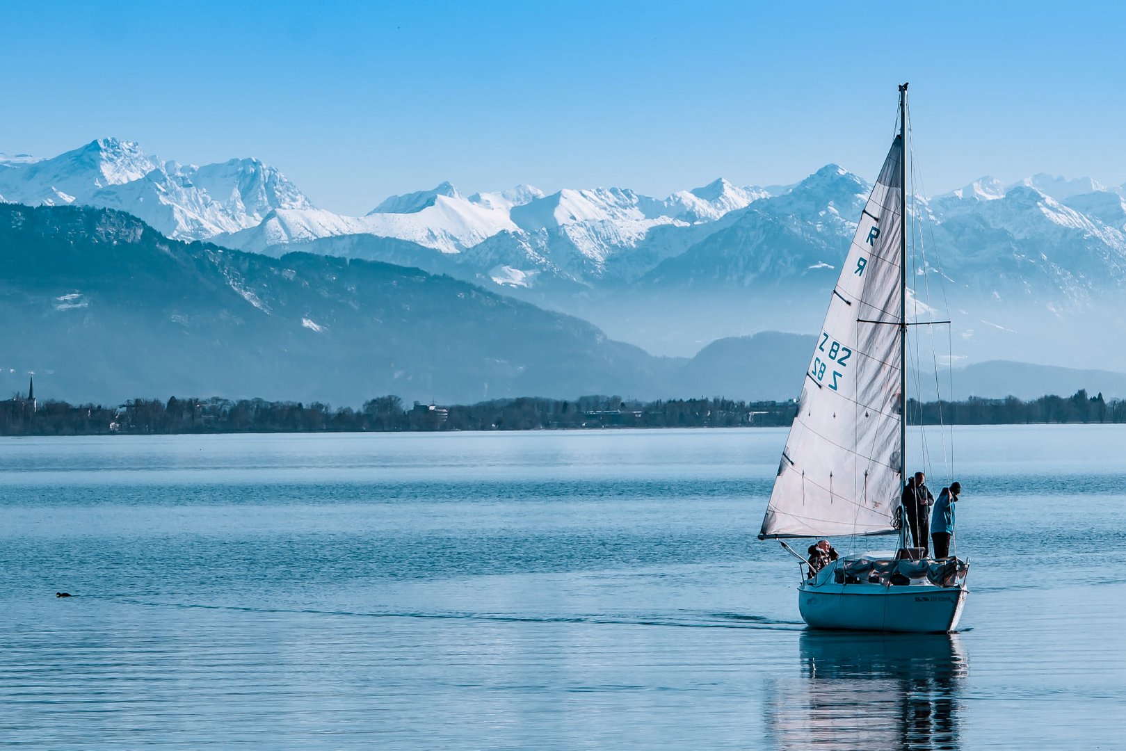 Segelboot mit Blick auf die Alpen