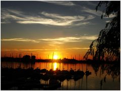 Segelboote im Hafen am See mit Sonnenuntergang und Wolkenspiel am Niederrhein