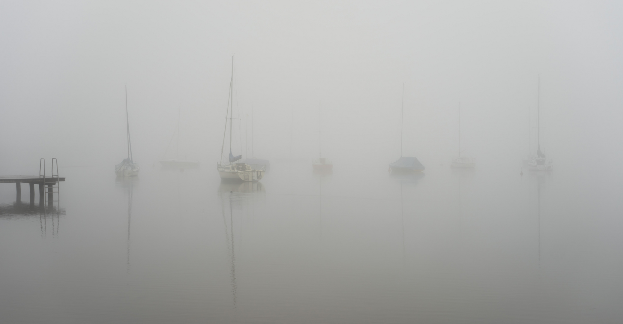 Segelboote vor Anker im Morgennebel auf Simssee