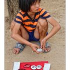 Selling her painted Stones on the side of the road