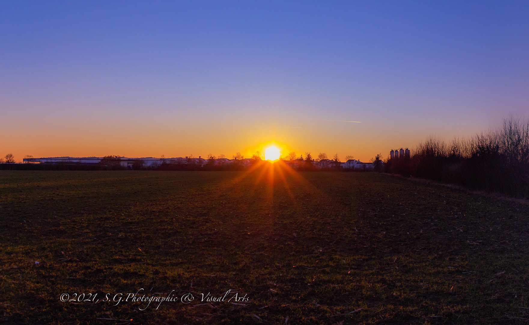 Setting sun beyond the solar park