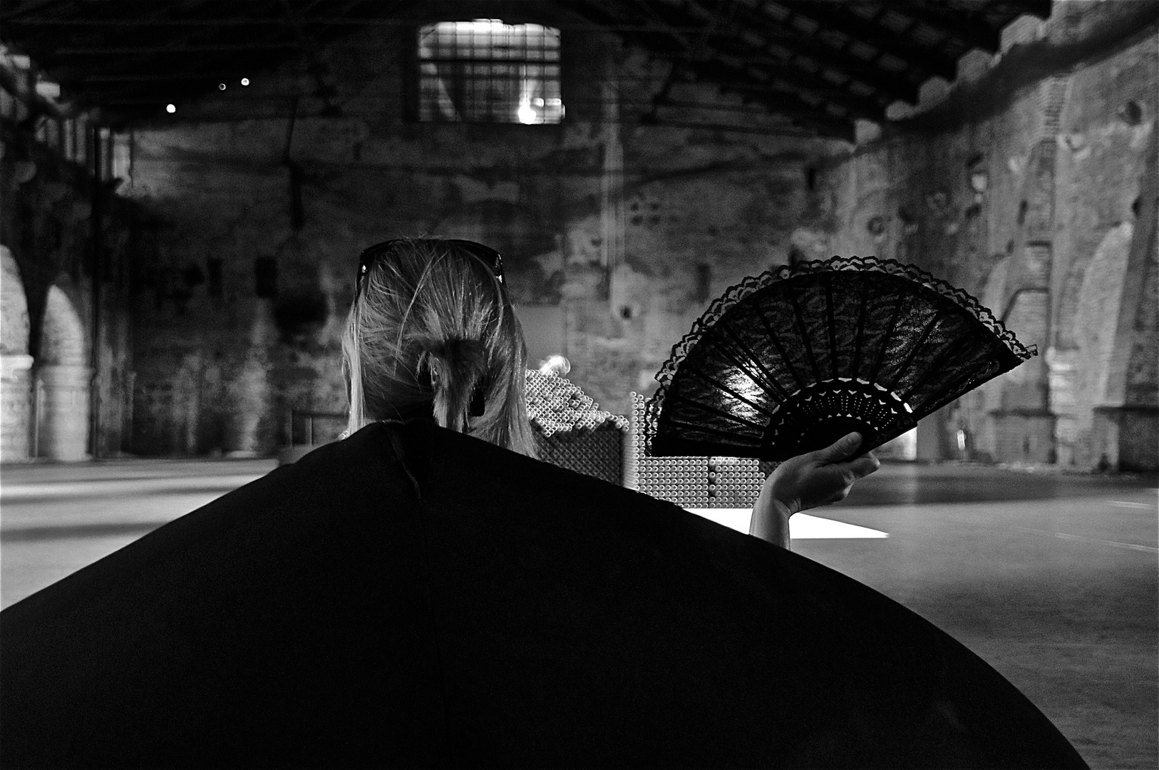 signora mit fächer auf schwarzem sitzmöbel, venedig august 2011