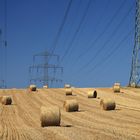 Silageballen auf dem Feld unter Hochspannungsmasten 