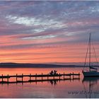 Silhouette von Paar mit Segelyacht bei Abendrot am Steg auf dem Steinhuder Meer bei Steinhude