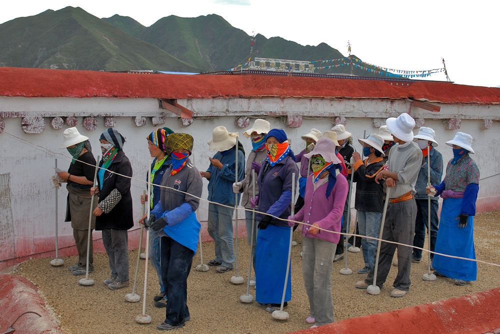 Singing roof workers flatten the ground