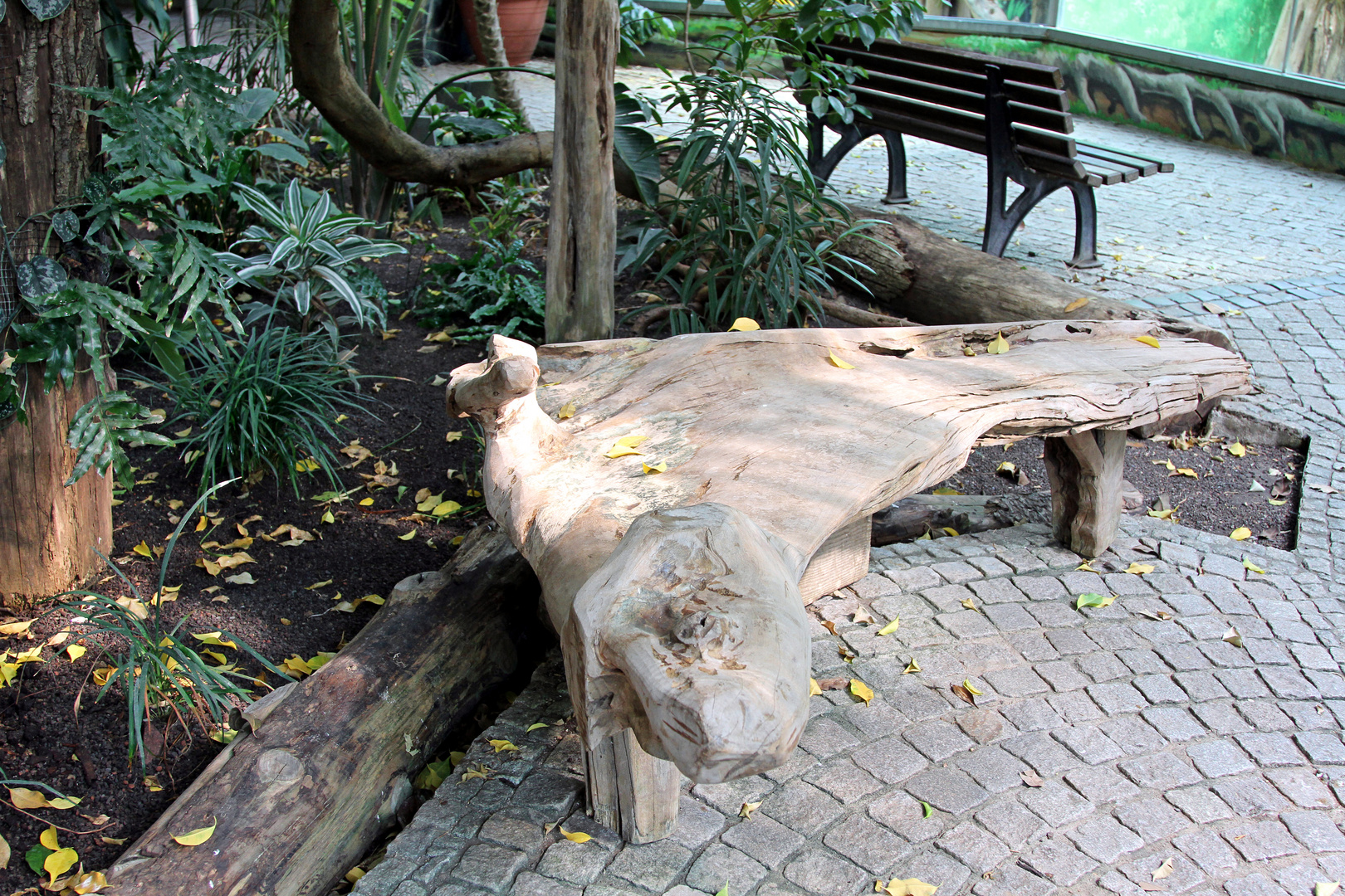 Sitzbank aus einem Holzstamm gebaut im Zoo Heidelberg