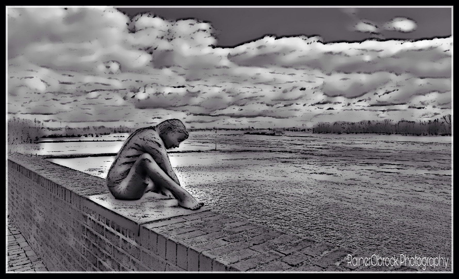 sitzend auf der Mauer am Rhein