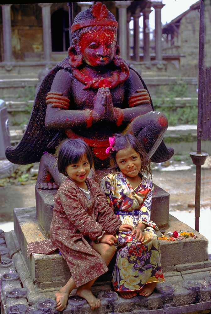 Small Newa girls in Lalitpur in front of Garuda statue