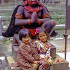 Small Newa girls in Lalitpur in front of Garuda statue