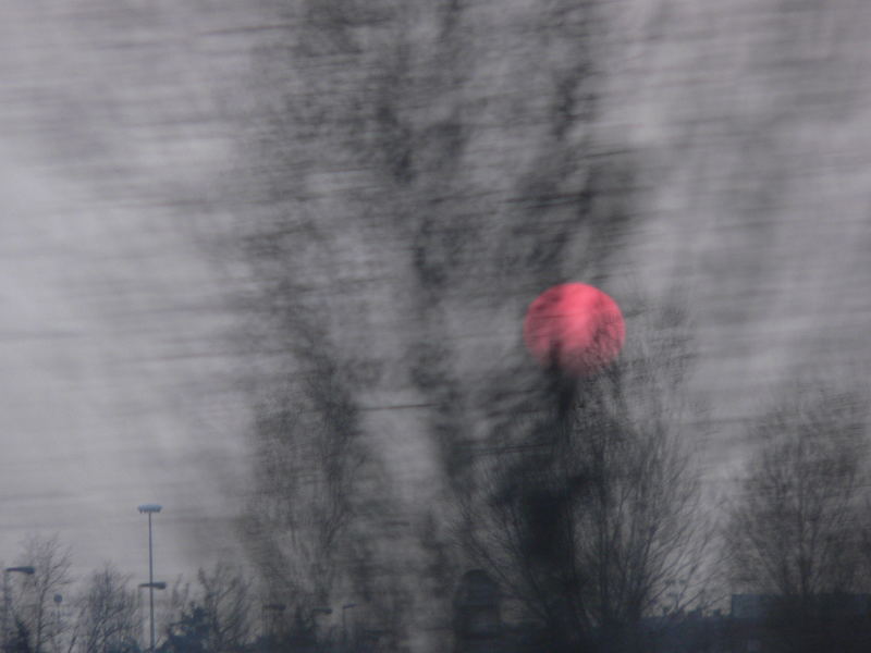 sole rosso su città grigia