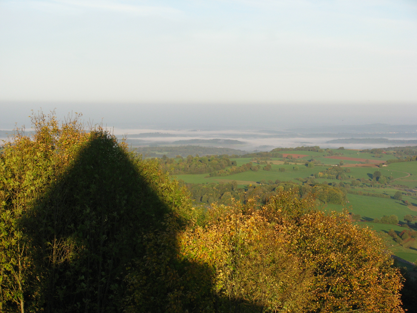 Sonne auf dem Berg und Nebel im Tal