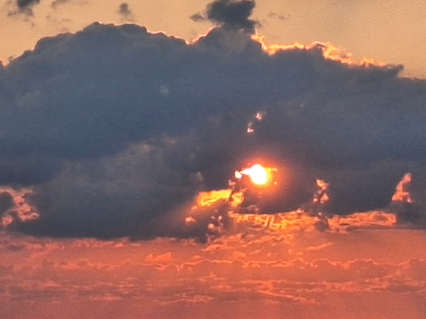 Sonne schaut hinter dunklem Wolkengebilde hervor