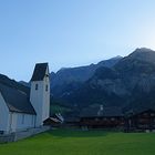 Sonne scheint durchs Martinsloch auf die Kirche von Elm