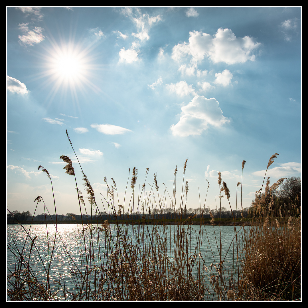 Sonne und Wolken gestalten den schönen blauen Himmel