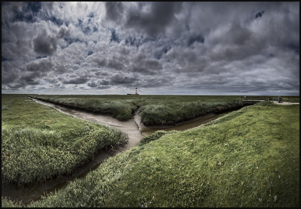 Sonne, Wolken und ein Leuchtturm