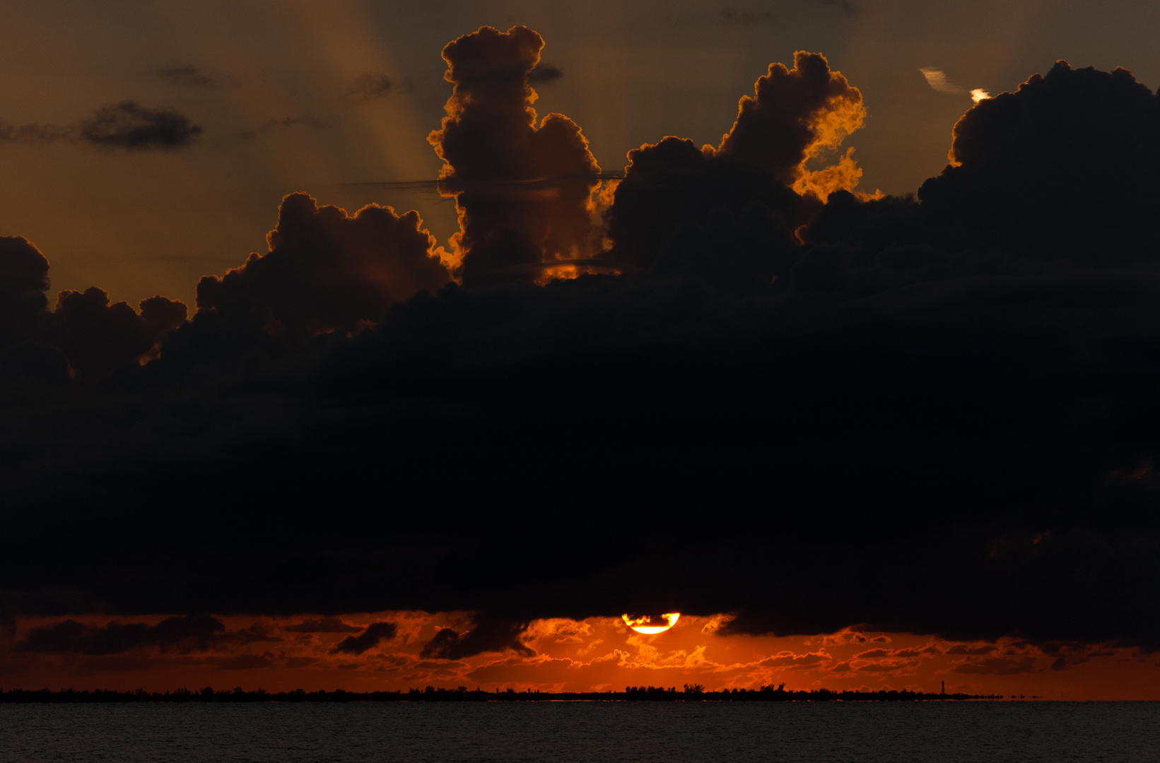 Sonne zwischen Meer und Wolken