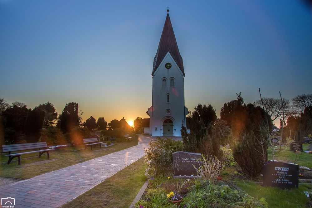 Sonnenaufgang an der Kirche von Nebel