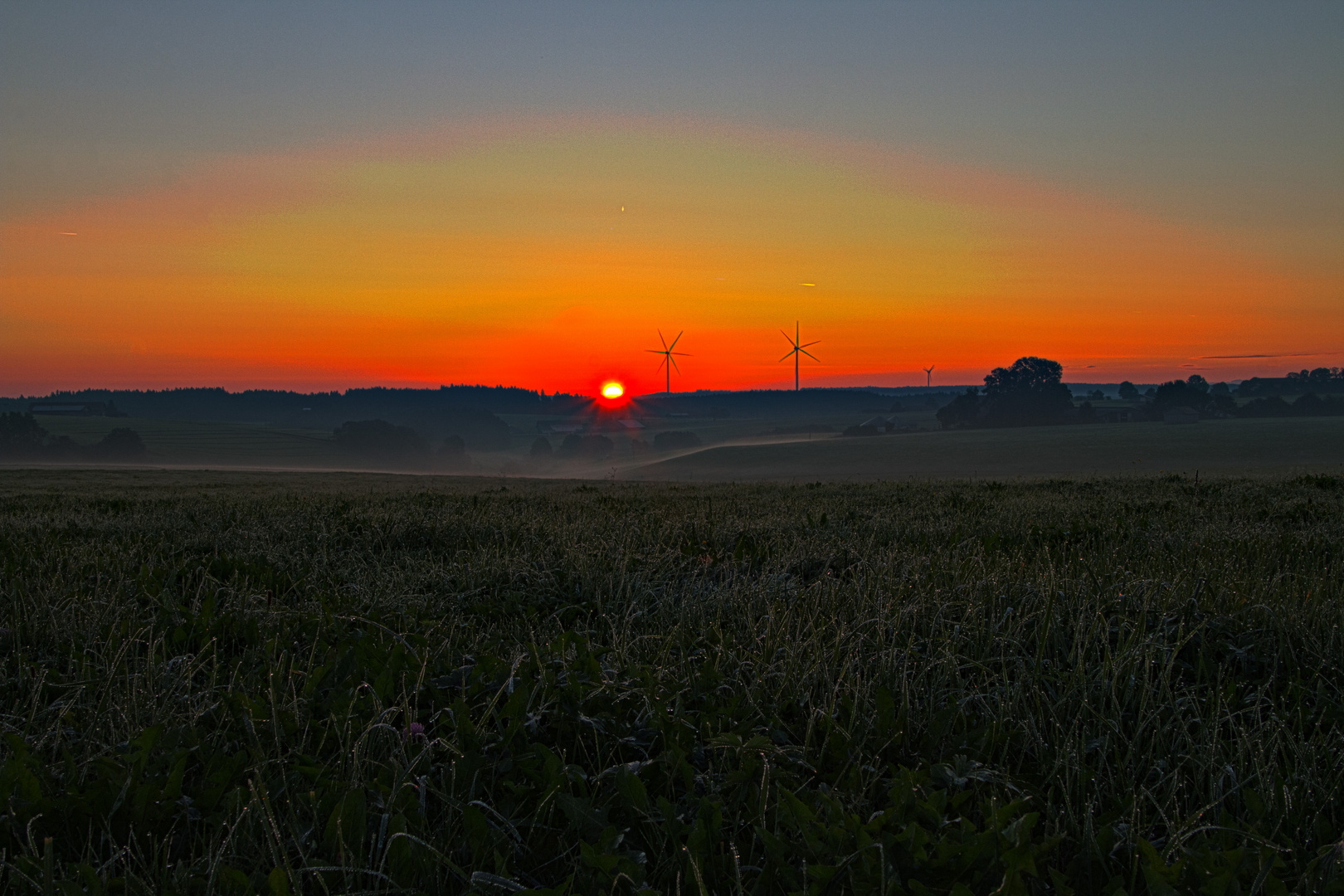 Sonnenaufgang an einer Windkraftanlage