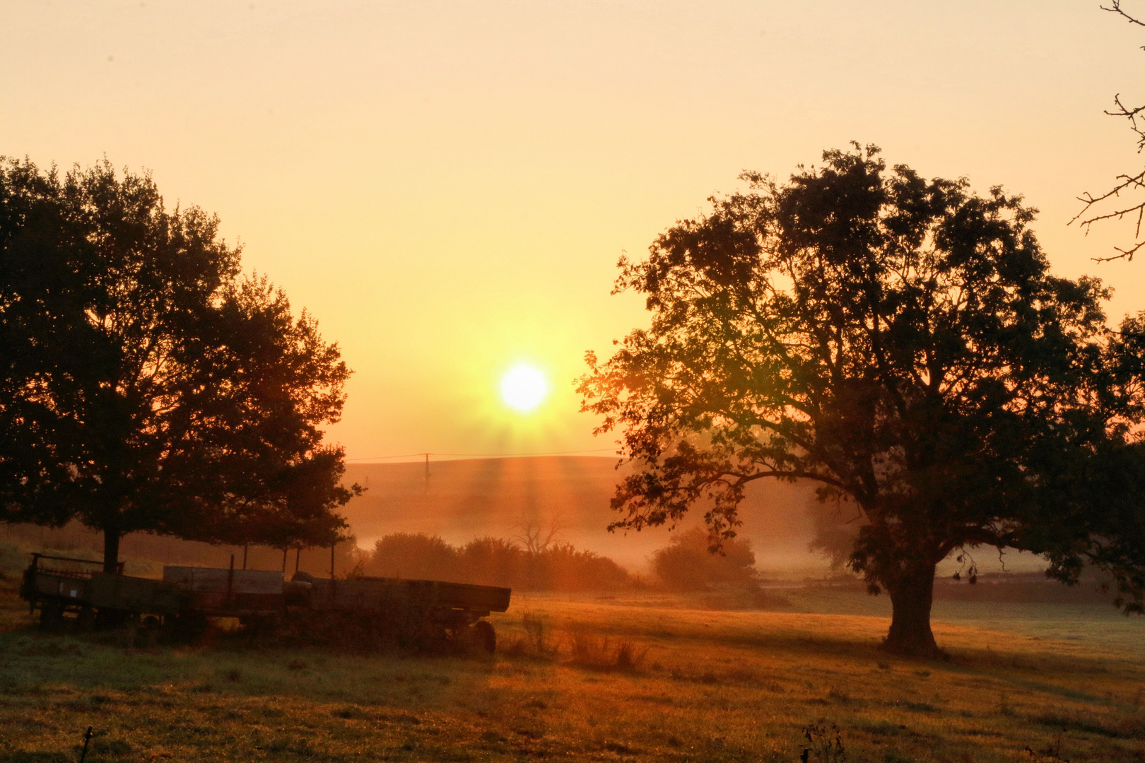 Sonnenaufgang auf dem Bauernhof - die Gerätschaften für den Acker im besten Licht