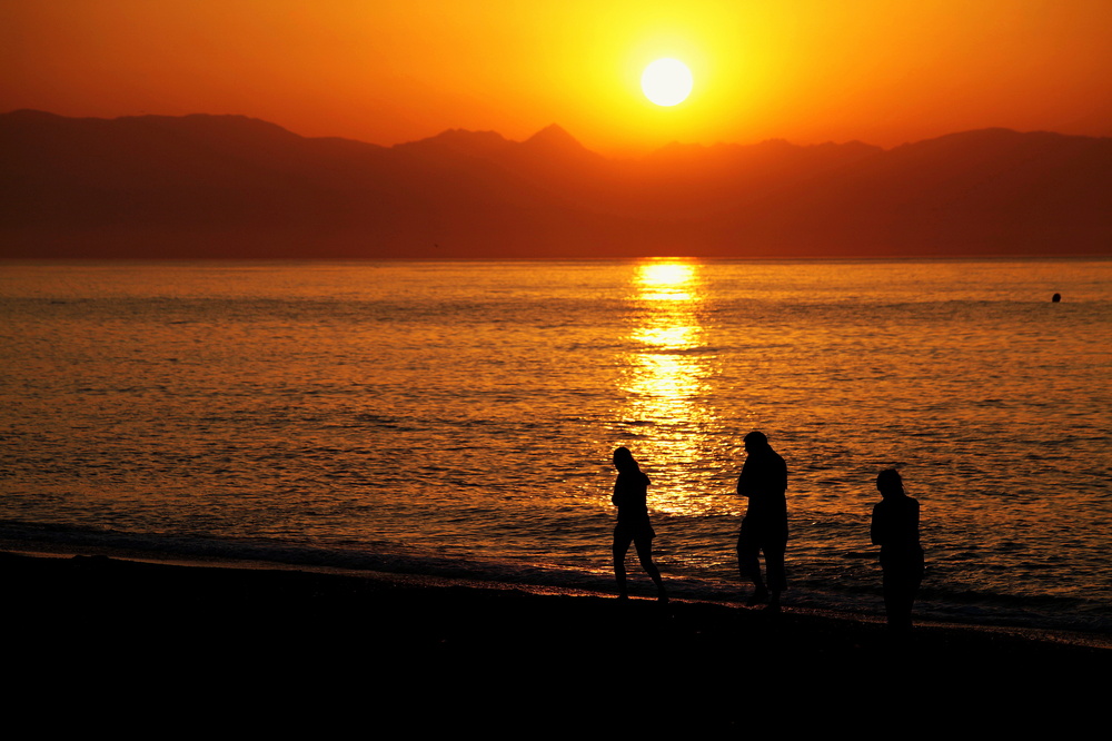 Sonnenaufgang in Torremolinos mit Menschen am Strand