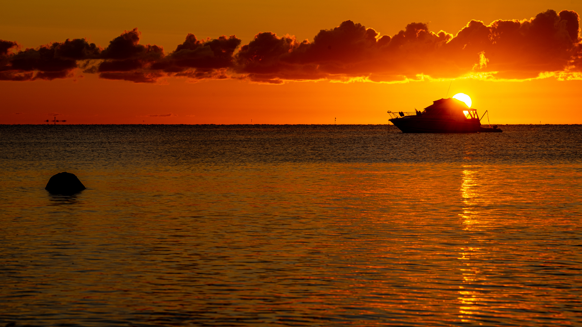 Sonnenaufgang mit brennendem Himmel und Boot