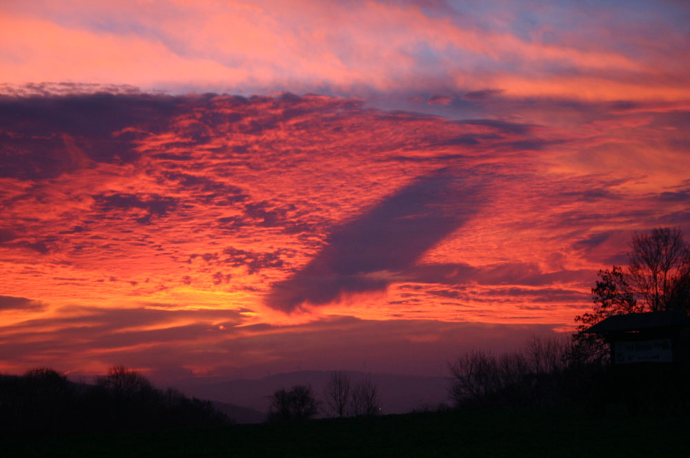 Sonnenaufgang mit großer Wolke unter der Wolkendecke