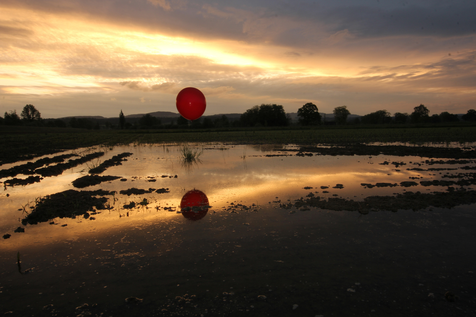 Sonnenaufgang mit rotem Ballon