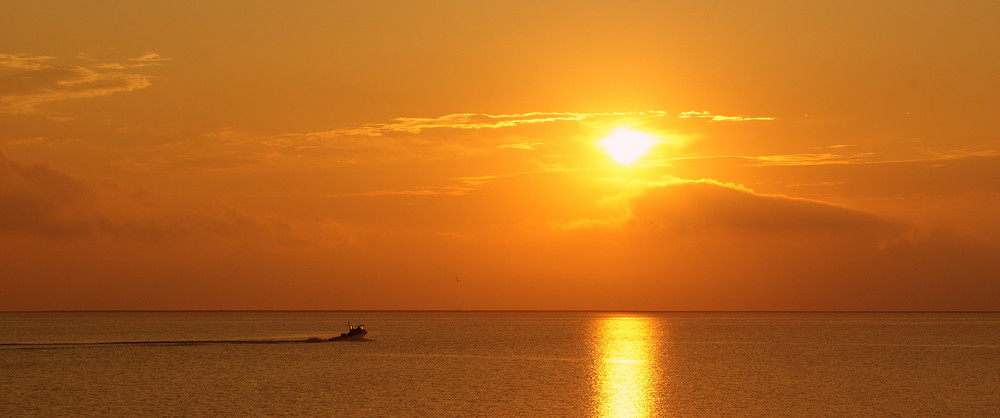 Sonnenaufgang - Sportfischerboot kreuzt