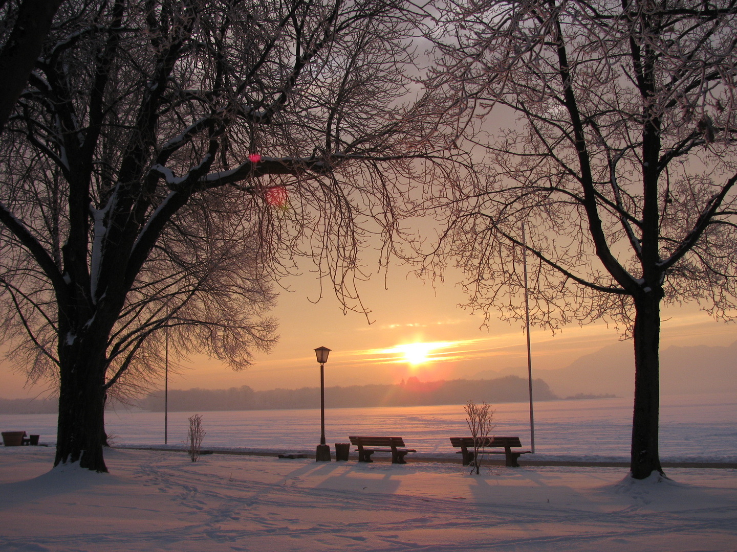 Sonnenaufgang über dem gefrorenen Chiemsee