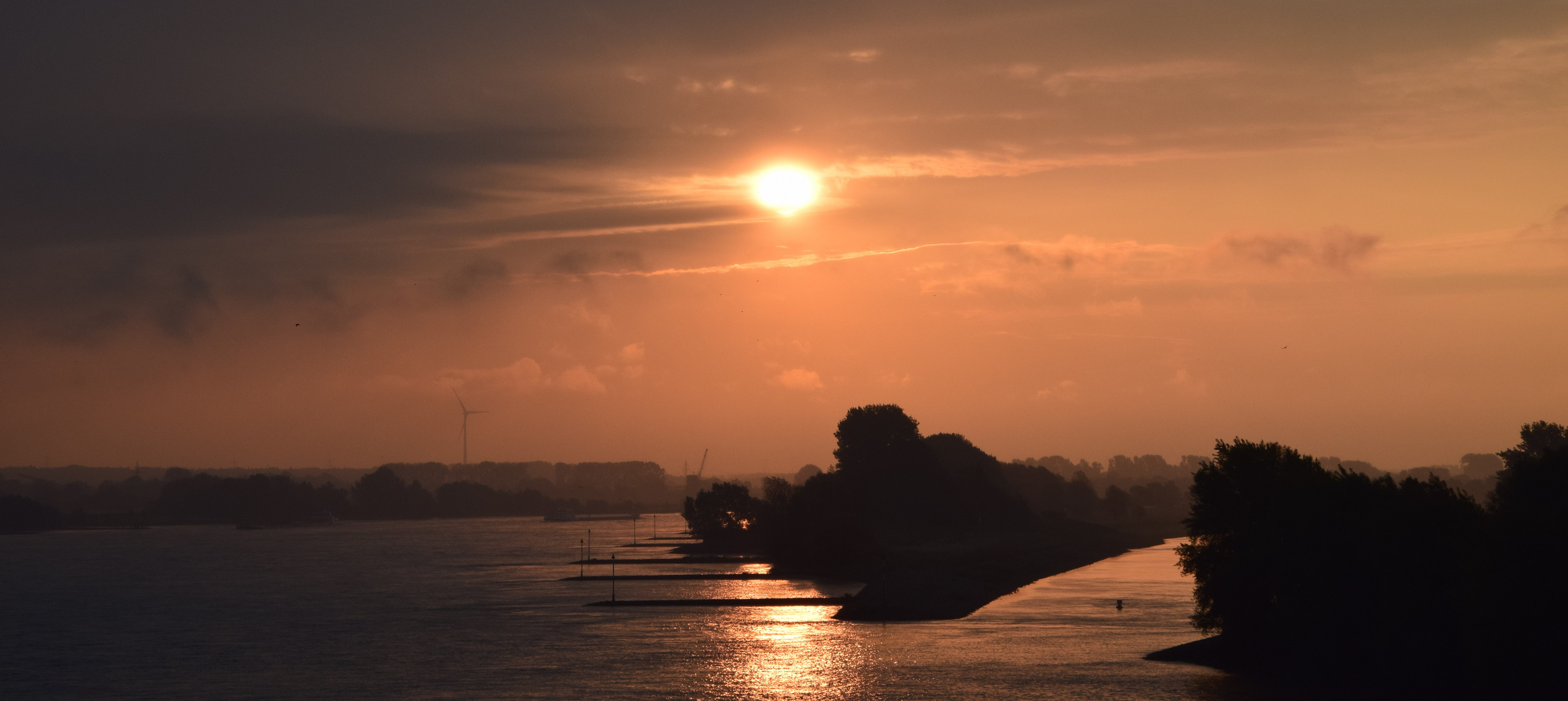 Sonnenaufgang über dem Rhein bei aufkommenden Regen