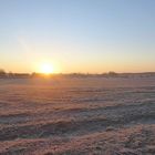 Sonnenaufgang über frostigen Wiesen