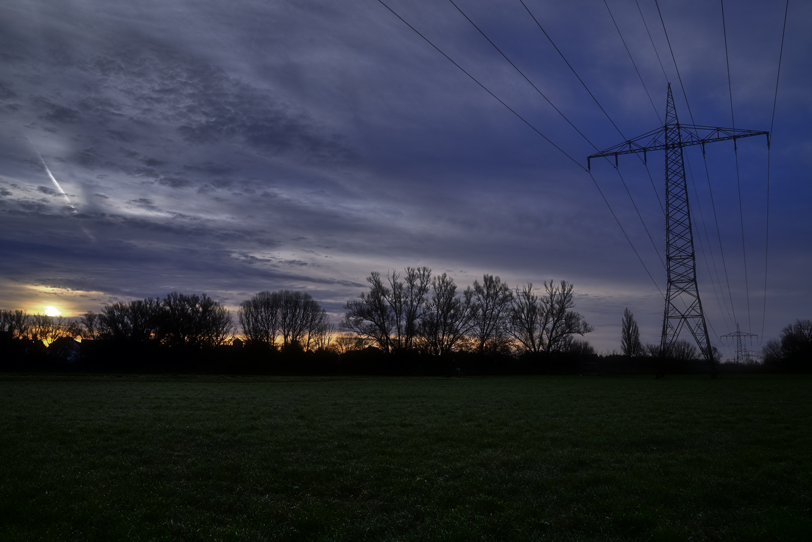 Sonnenaufgang und Freileitungsmast