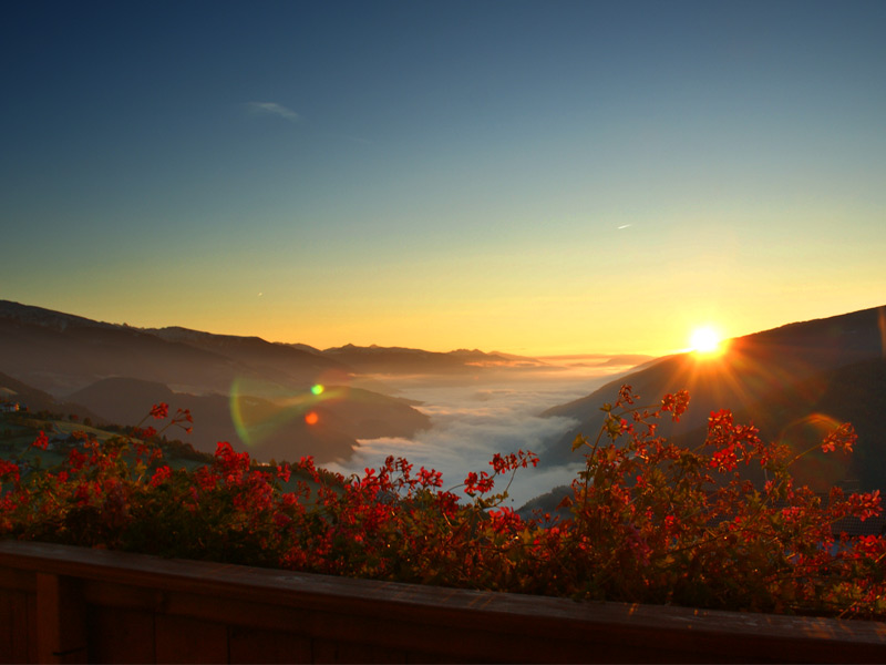 Sonnenaufgang von Hotelbalkon mit Blick auf das mit Nebel bedeckte Pustertal