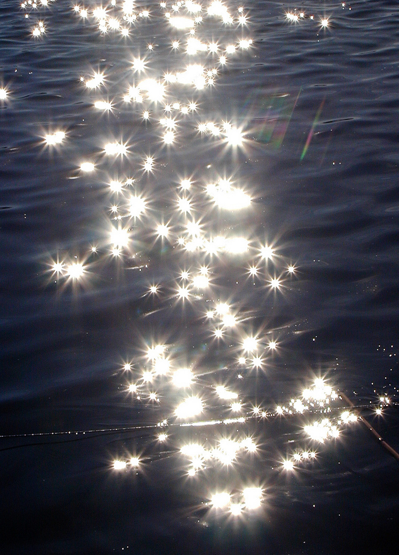 Sonnenstrahlen spiegeln auf der Wasser-Oberfläche