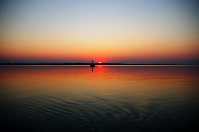 sonnenuntergang am dümmer mit schiff, haubentaucher und anständiger vignettierung