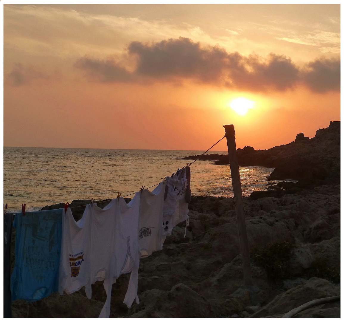 < Sonnenuntergang am Hafen von Lefkos >