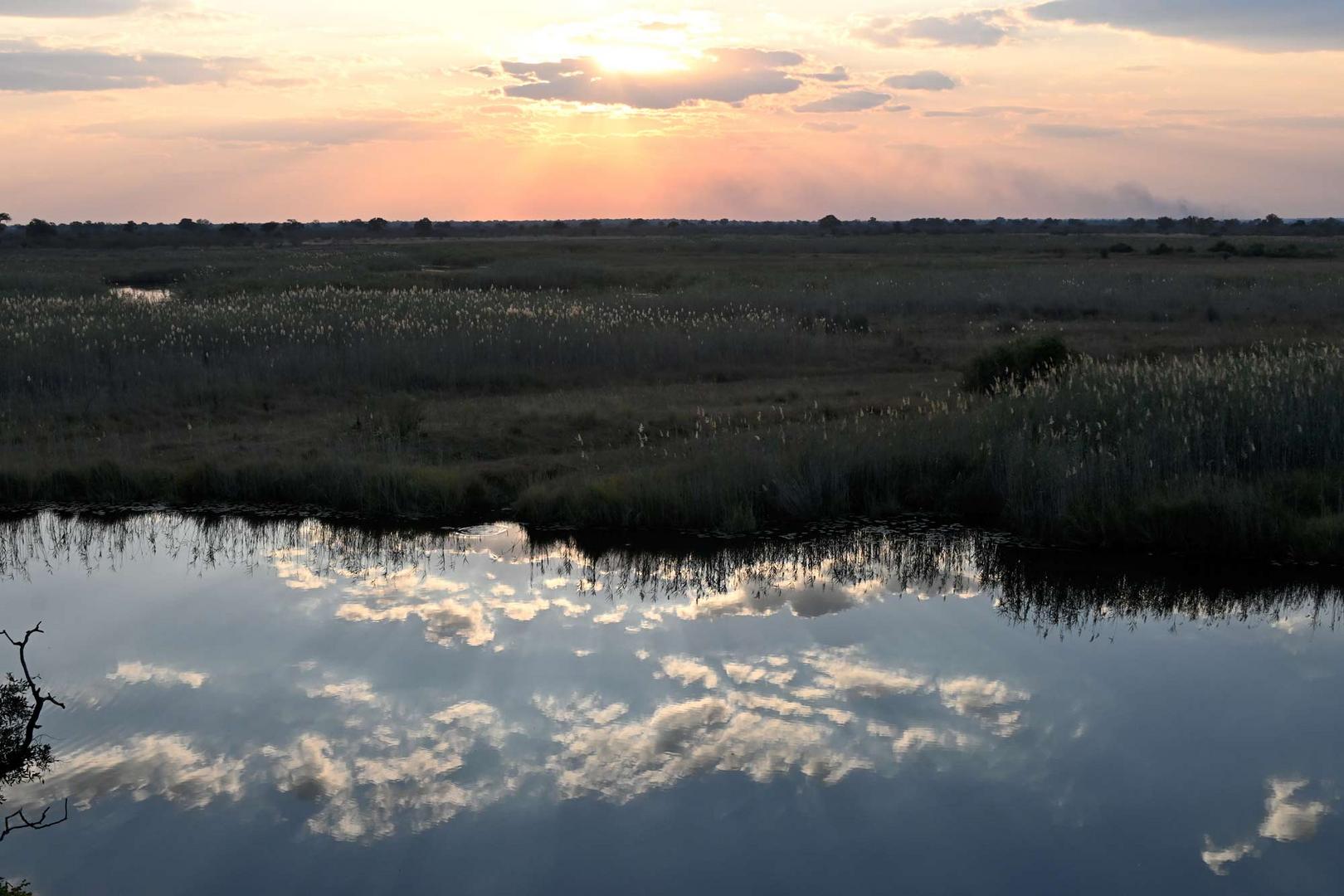 Sonnenuntergang am Kwando mit Wolkenspiegelung