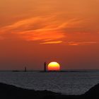 Sonnenuntergang am Meer mit einem Leuchtturm