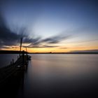 Sonnenuntergang am Steg mit einsamen Boot