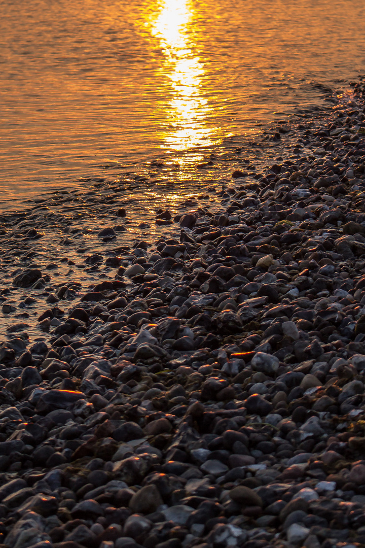 Sonnenuntergang am Steinstrand