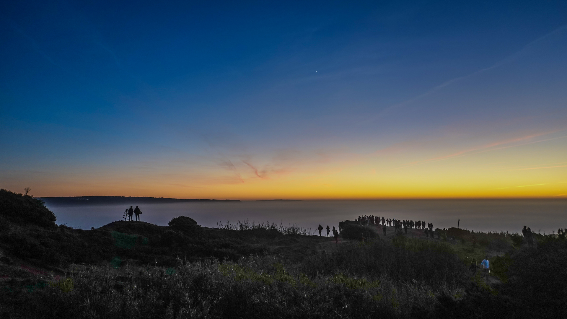 Sonnenuntergang am Strand, der Bodennebel liegt wie ein Schleier über dem Meer