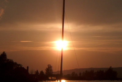 Sonnenuntergang direkt hinter Segelboot