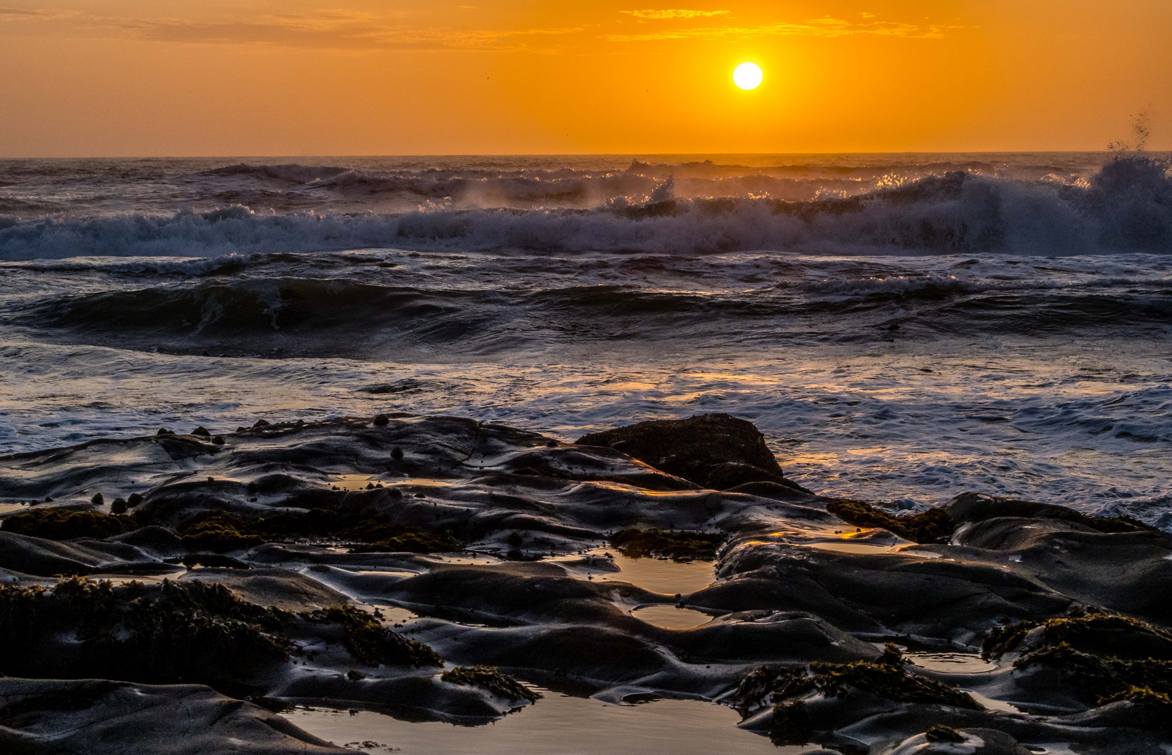 Sonnenuntergang hinter der Brandung