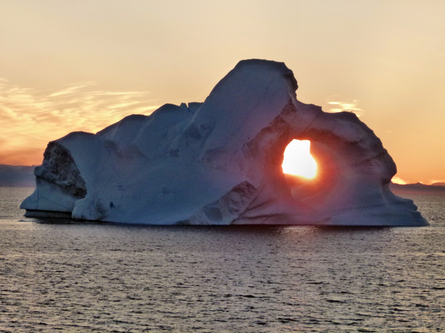 Sonnenuntergang im Loch eines Eisberges vor Grönland 