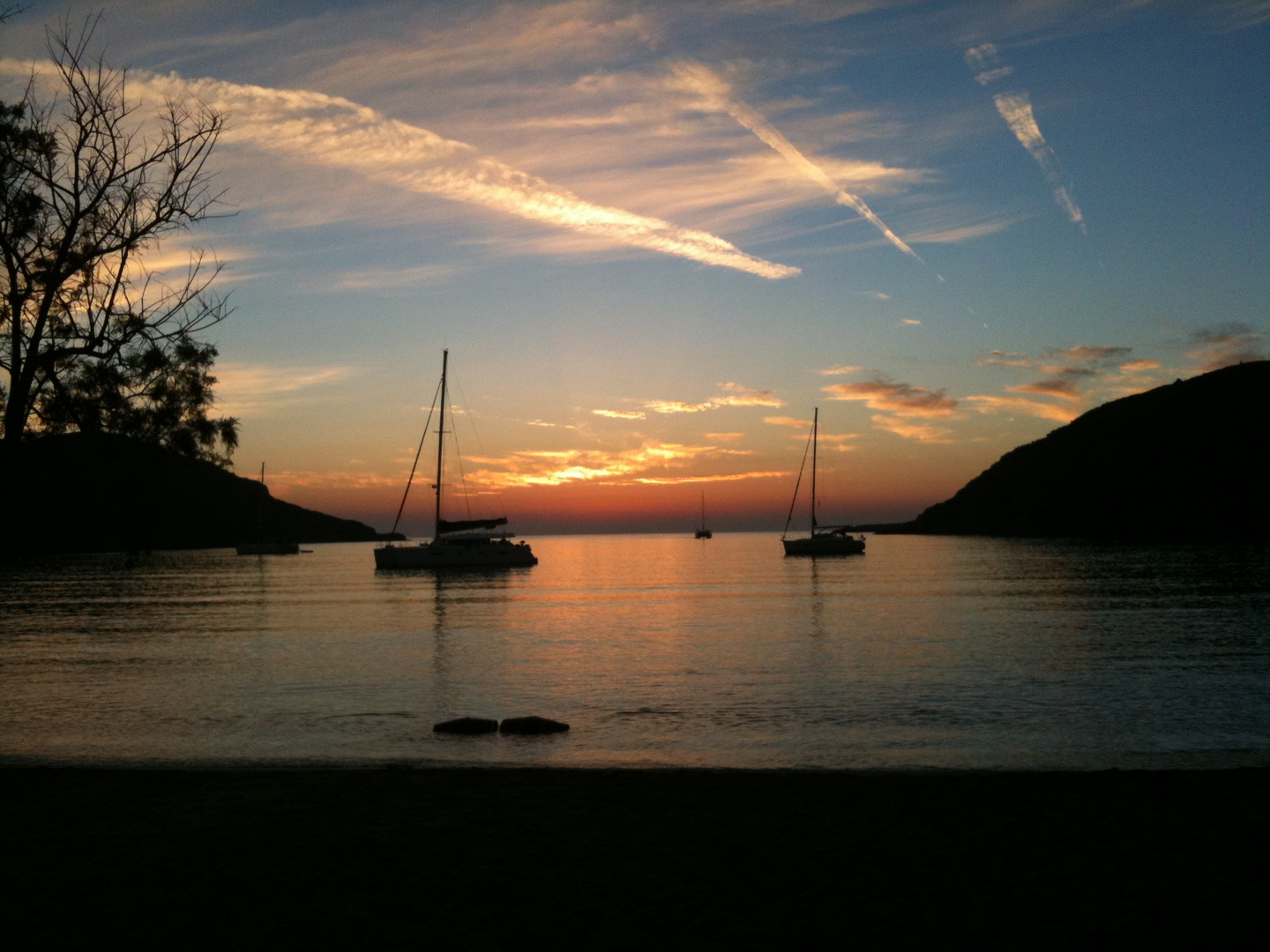 Sonnenuntergang in der Bucht mit Segelbooten