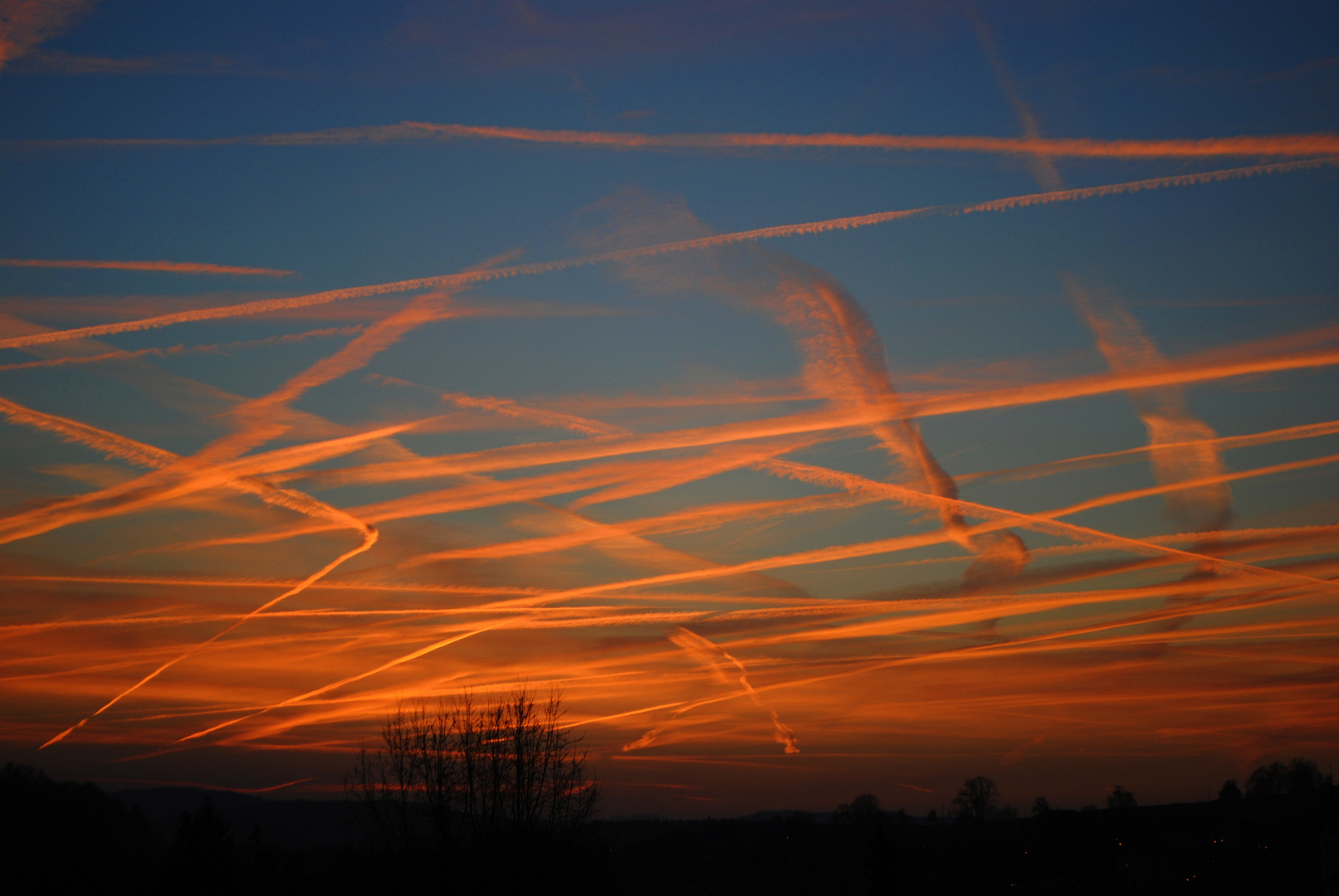 Sonnenuntergang mit Flugzeugstreifen