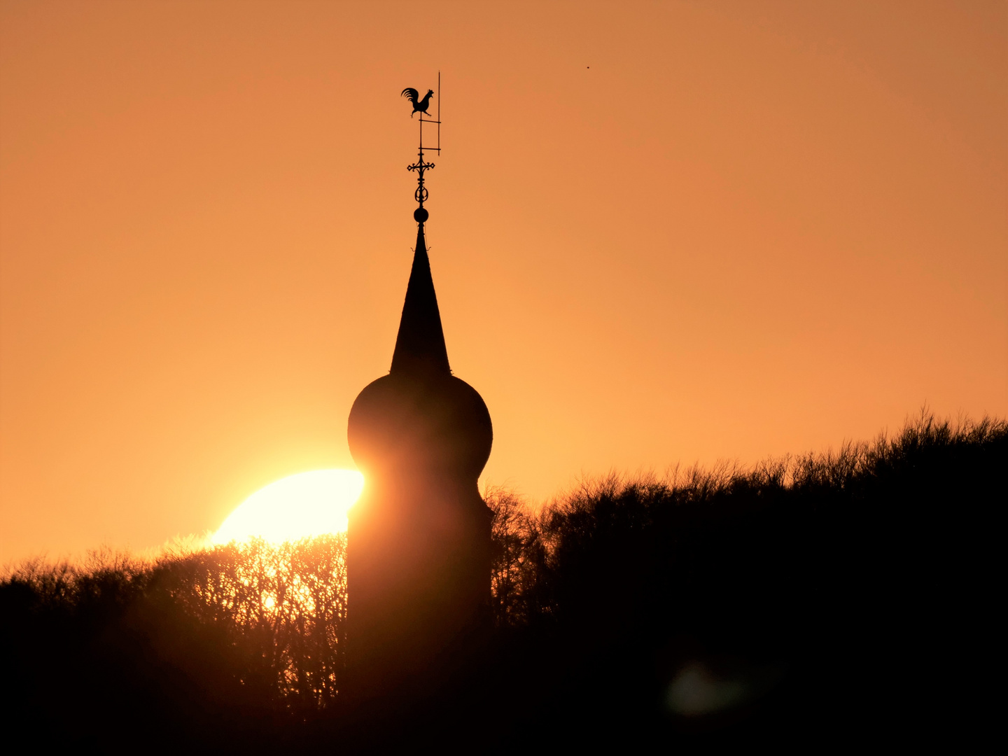 Sonnenuntergang mit Glockenturm.