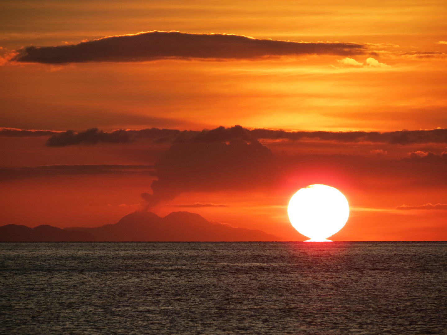 Sonnenuntergang mit qualmendem Vulkan