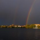 Sonnenuntergang mit Regenbogen am Straussee mit Stadtblick